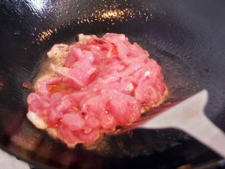 京酱肉丝,热锅凉油，倒入腌制好的肉丝。翻炒至肉丝变色。