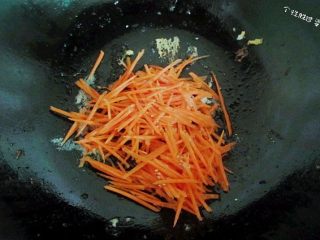时蔬冷面,锅内放入少许油，加盐和鸡精煸炒一下胡萝卜。胡萝卜过油才可以把维生素胡萝卜素释放出来