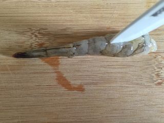 丝瓜酿虾,在虾仁中间用刀划一个口。
