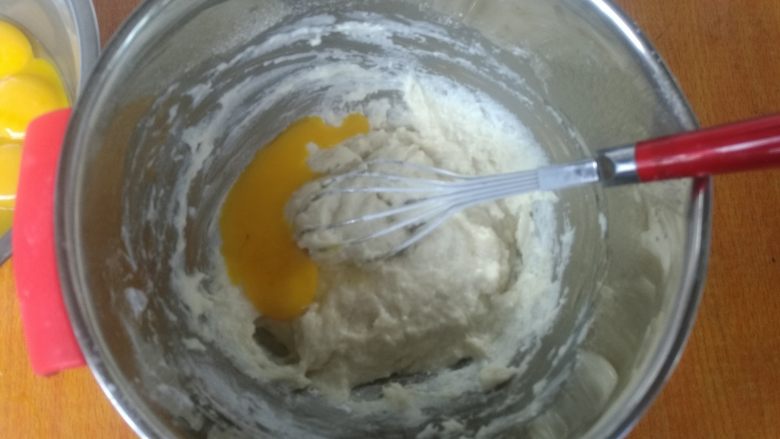 八寸加高中空戚风,加入蛋黄，开始一个一个加，搅拌均匀，4个后全部加进去。