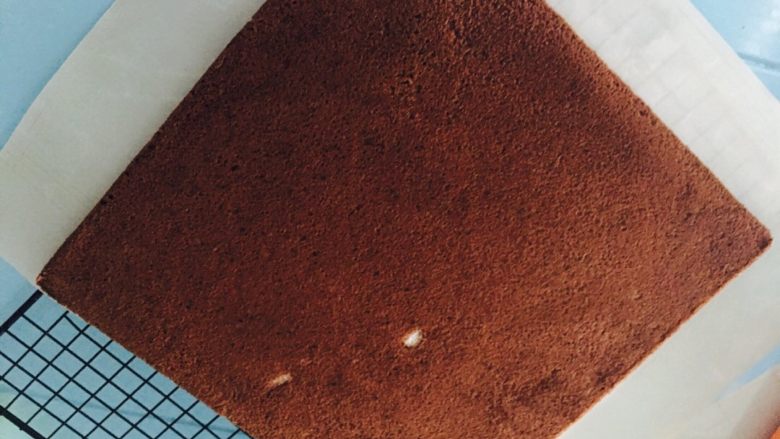 巧克力奶油蛋糕卷,取出撕下油布，放至温热