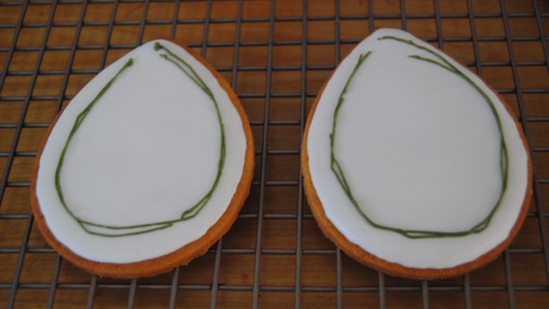 花环糖霜饼干,取出干透的糖霜饼干，用深绿色的糖霜拉出藤线