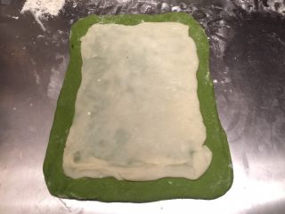 抺茶麻薯软欧,案板洒少许干粉，将主面团擀成长方形，麻薯分成3份，也分别长方形，分别叠放在主面团上