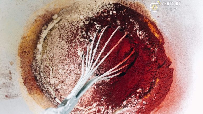 红丝绒、抹茶、芒果三色奶油盒子,筛入蛋糕粉和红曲粉，蛋抽由下往上翻拌均匀。