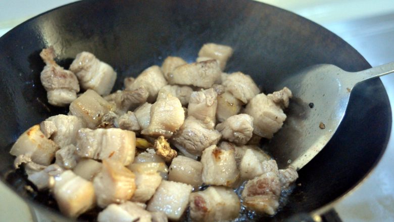红烧肉,翻炒，炒至五花肉变色微发黄，炒出部分的油。