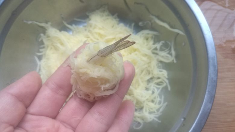 金丝凤尾虾,土豆丝控干水分，加入适量盐拌匀，用土豆丝包裹住虾，捏成球状。