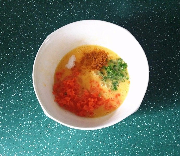 鸡蛋米饭饼,放入食盐、香葱、咖喱及胡萝卜拌匀