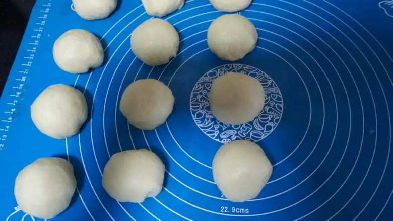 日本牛奶卷,分成12个相同的圆剂子，用保鲜膜松弛15分钟，用手按扁排气。