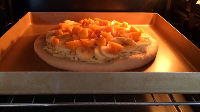香蕉芒果披萨,放入预热好的烤箱中层，上下火200度烤6分钟。