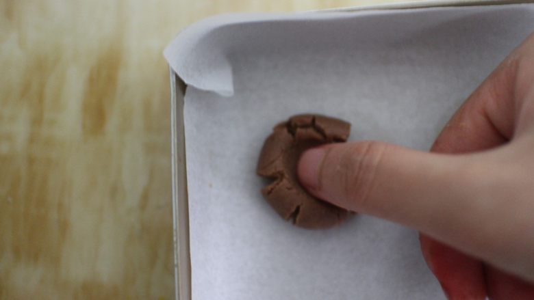 巧克力豆玛格丽特饼干,放在烤盘上，用大拇指去按压它，使它形成一个自然的裂痕即可