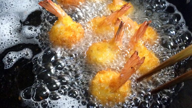 黄金虾球,在锅内倒入食用油，烧至六七成热，把虾球入油锅内炸制，虾球刚下过别急的翻动。待虾球一定炸制固定了再翻动其他面继续炸制。