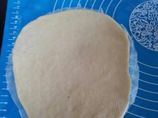 网纹红豆面包,剪一块和八寸圆模差不多的油纸，将擀卷好的面团放到油纸上面。