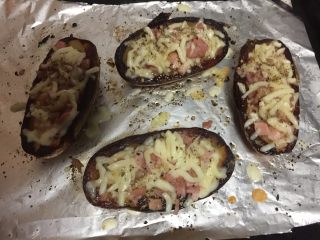 烤土豆皮,放入马苏里拉芝士、培根碎、撒上黑胡椒碎、披萨草和葱花