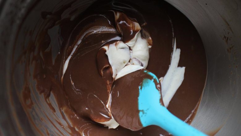 黑巧慕斯盒子蛋糕,将打发好的奶油取一部分与巧克力混合液翻拌均匀，是翻拌，不是画圈圈，切记