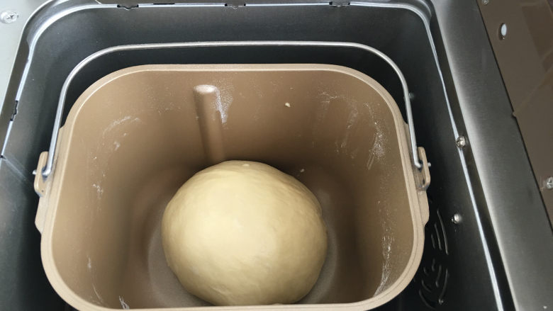 香酥肉松面包,将面团重新整圆后放入面包机中，选择发酵解冻菜单进行一次发酵，时间设定为30分钟。