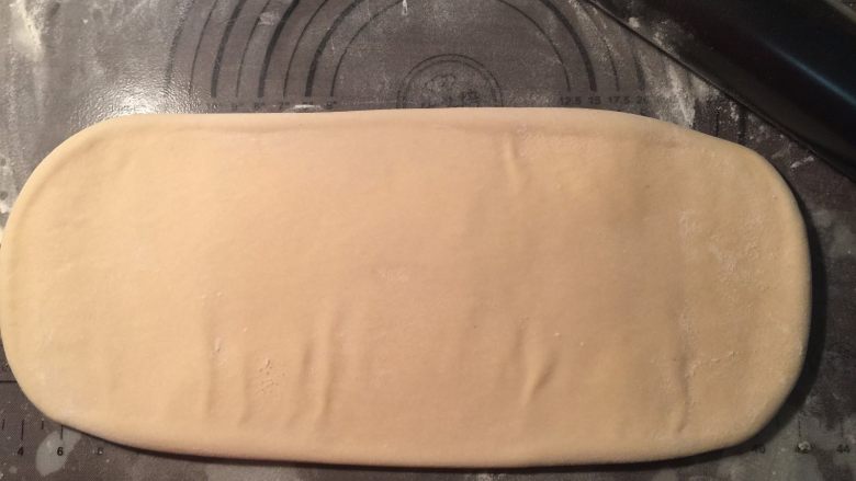 流沙起酥包,用擀面杖把包好黄油的面片，再次擀开成为长方形薄面片