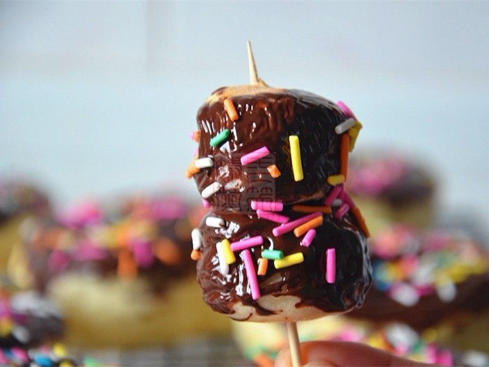 巧克力甜甜圈,甜甜圈的小圆心，每两个用牙签串起来，也刷上巧克力，撒上巧克力糖针， 巧克力糖葫芦就诞生了。