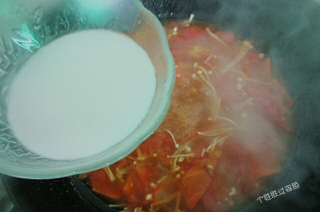 番茄金针菇蛋汤,锅里的汤煮沸后，加入水淀粉进行勾芡