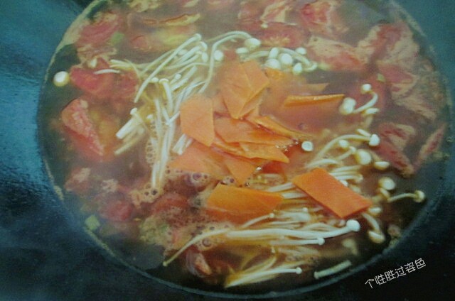 番茄金针菇蛋汤,汤煮开后加入金针菇和胡萝卜片