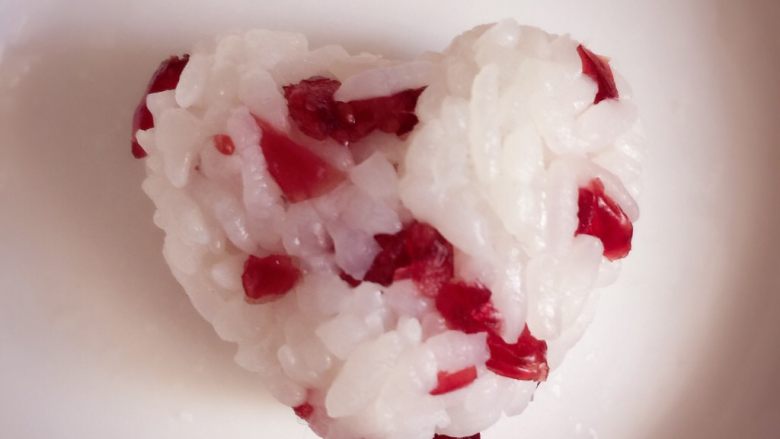 寿司🍣版的欢乐颂五美,切好后，拿一小团米饭和蔓越莓混合，用手捏成心形。手上也要沾水，不然米饭很容易粘手。