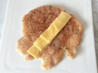 培根奶酪鸡肉卷,在撒过胡椒和盐的那面中间放上切条的奶酪片。