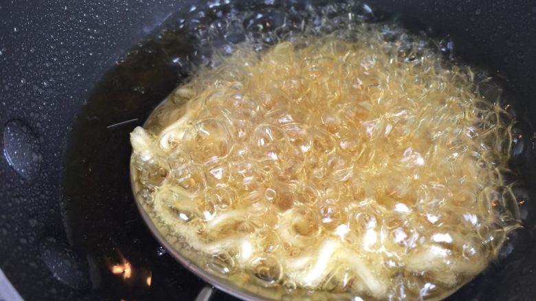 鲜虾脆面盏, 漏勺在热油里炸至定型。