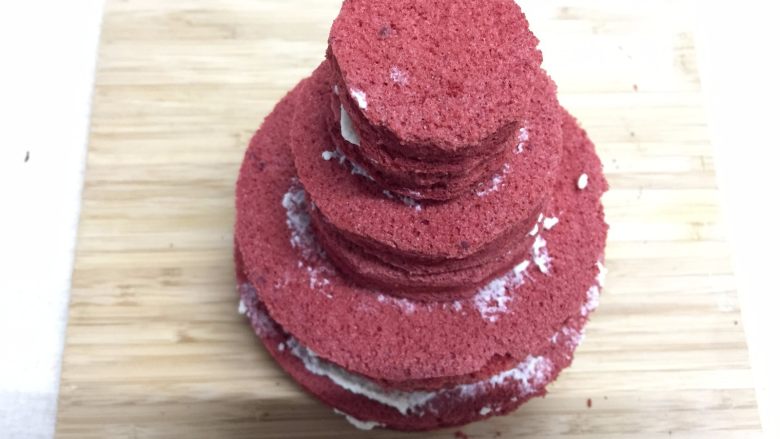 迷你红丝绒裸蛋糕,每一片蛋糕片上都抹上薄薄的一层奶油，从大到小叠上去