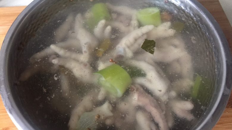 酸辣鸡脚,把煮熟的鸡爪捞出，放进事先准备好的冷开水里浸泡至完全冷却。