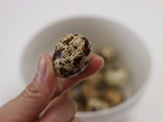 五香鹌鹑蛋,
用手将蛋壳捏碎，注意不要把鹌鹑蛋捏破了