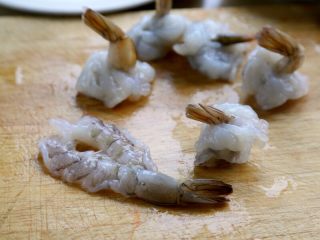 鲜虾酿西葫芦盅,4.然后将虾子的上部戳个洞，虾尾向上穿过洞，如图。
