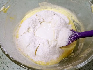 香蕉酸奶磅蛋糕,分3次筛入低筋粉、泡打粉和倒入酸奶，用刮刀拌匀。