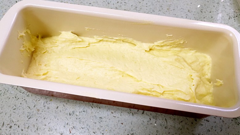 香蕉酸奶磅蛋糕,烤箱预热160度。把一半蛋糕糊舀入模具。