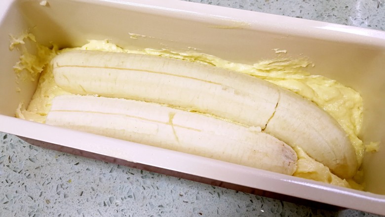香蕉酸奶磅蛋糕,把香蕉放在蛋糕糊上，轻轻向下压一下。