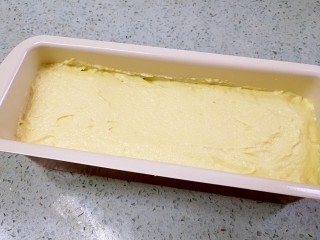 香蕉酸奶磅蛋糕,把剩下的蛋糕糊全部倒入模具，覆盖香蕉，抹平表面。
