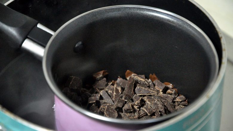 心型调温巧克力,用隔水加热法，热水温度在60°c为最佳，往同一个方向不断搅拌，注意不要让水汽进入巧克力内。