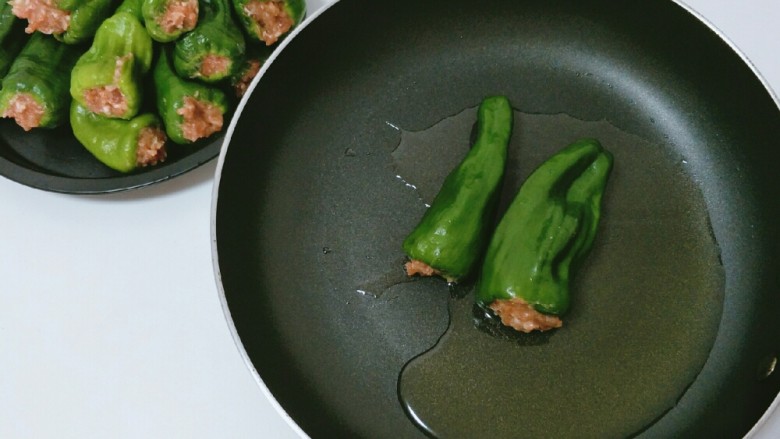辣椒酿肉,平底不粘锅内放入色拉油。用中火煎至肉沫发白。记得翻面。