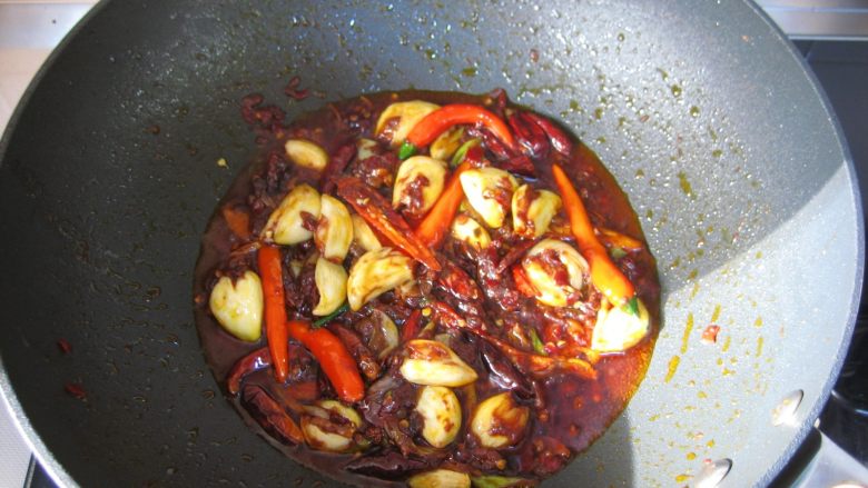 川香麻辣烤鱼：麻辣过瘾的豪华烤鱼,改成小火继续炒至出红油，再放入小米椒炒至变软。

