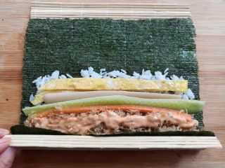 金顶寿司,提起寿司帘的末端，紫菜包住饭团的材料