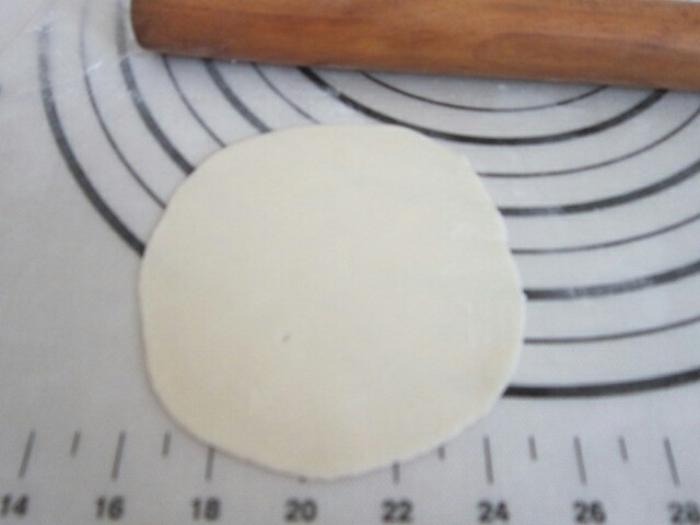 玉米猪肉水饺,用擀面杖擀成厚薄均匀的面皮。