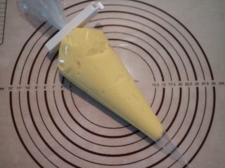 超软流心奶黄包,取出冷藏好的奶黄馅，用打蛋器重新搅打顺滑，装入裱花袋。
因为今天用到的奶黄馅流动性较好，无法用手搓成团，所以在包法上也有改变