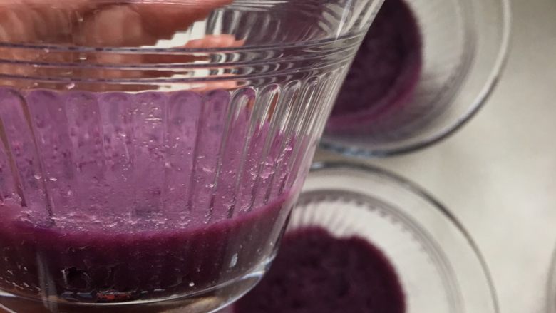 紫薯慕斯蛋糕,取和黄油搅拌均匀的紫薯泥放入杯底，压实，入冰箱冷藏备用