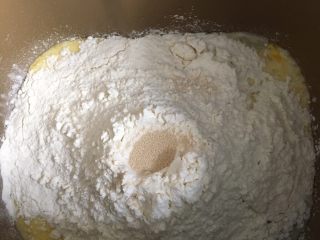 椰蓉花朵面包,用后油法把材料放入面包机进行揉面，糖和盐以对角线放。