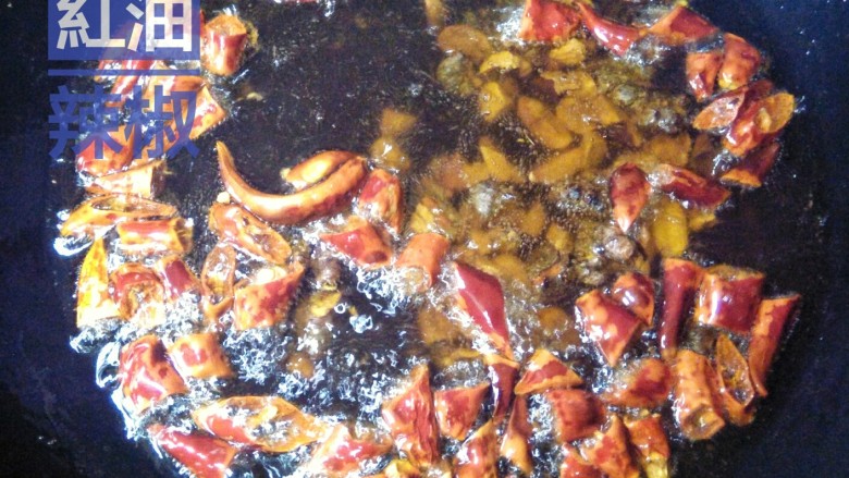 红油辣椒,花生碎稍微变色，立即投入备好的干辣片，锅里随即起沫。