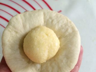 超软椰蓉面包,取一份松弛好的小面团，擀成圆皮状，包入一份椰蓉馅。
