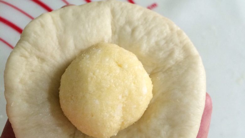 超软椰蓉面包,取一份松弛好的小面团，擀成圆皮状，包入一份椰蓉馅。