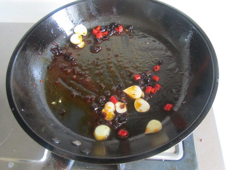 豆豉辣炒茄子土豆片,锅中加入豆豉香辣酱、红椒和蒜片爆香；