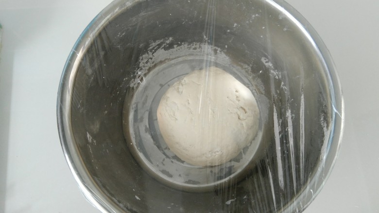 小花猫花样馒头,揉好后，盖上保鲜膜发酵，再用筷子在保鲜膜上戳一个洞。