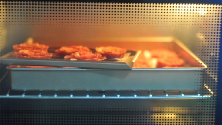 玫瑰花杏仁曲奇饼,放紧预热好的烤箱里，130度烤50分钟后覆盖上锡纸，转180度烤6分钟，取出冷却