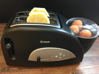 童趣早餐——乌龟全麦三明治,将鸡蛋放入煮蛋盘中，盖上盖子，接通电源，选择“烤面包/煮蛋”功能。