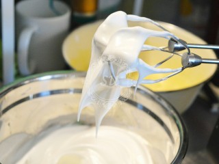 夏日清爽柠檬乳酪杯子蛋糕,我们制作的这款杯子蛋糕并不添加泡打粉，所以蛋白我们需要打到硬性。蛋白可以在打蛋头上保持直立的尖角。这一步骤时烤箱开始180℃预热